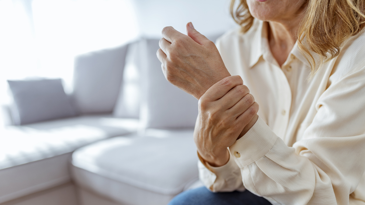 Senior woman rubbing her wrist and arm suffering from rheumatism